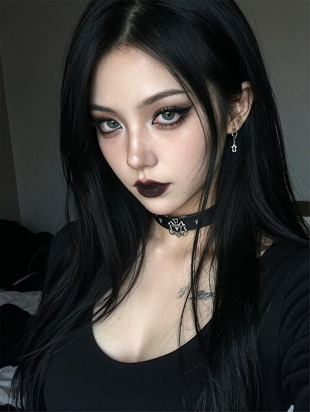 Dark-haired woman dressed in black against a near-black room, on the live anime girlfriend chat overlay